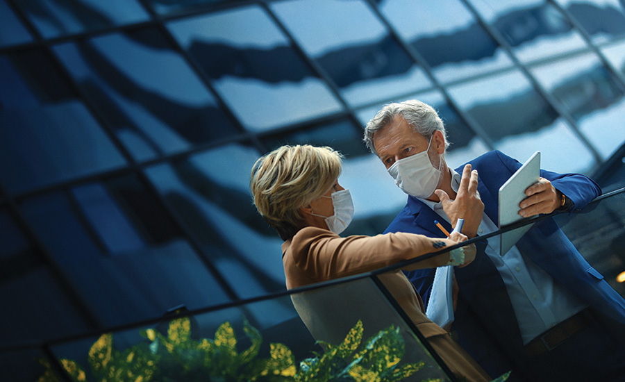 man and woman in evening clothes and masks